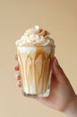Female hand holding glass of caramel frappuccino. Royalty Free Stock Photo